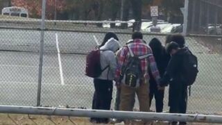 This woman randomly looks over and sees a group of teenagers praying in a circle. Then as they finish she applauds them.
