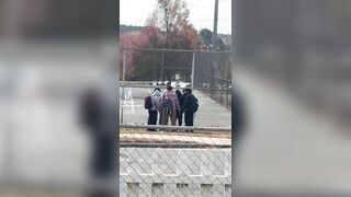 This woman randomly looks over and sees a group of teenagers praying in a circle. Then as they finish she applauds them.