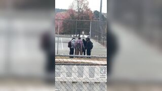 This woman randomly looks over and sees a group of teenagers praying in a circle. Then as they finish she applauds them.