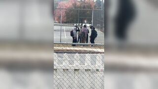 This woman randomly looks over and sees a group of teenagers praying in a circle. Then as they finish she applauds them.