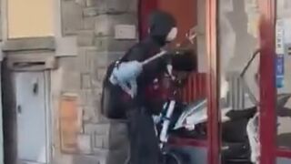 Migrant armed with a vacuum cleaner smashes the window of a motorcycle shop